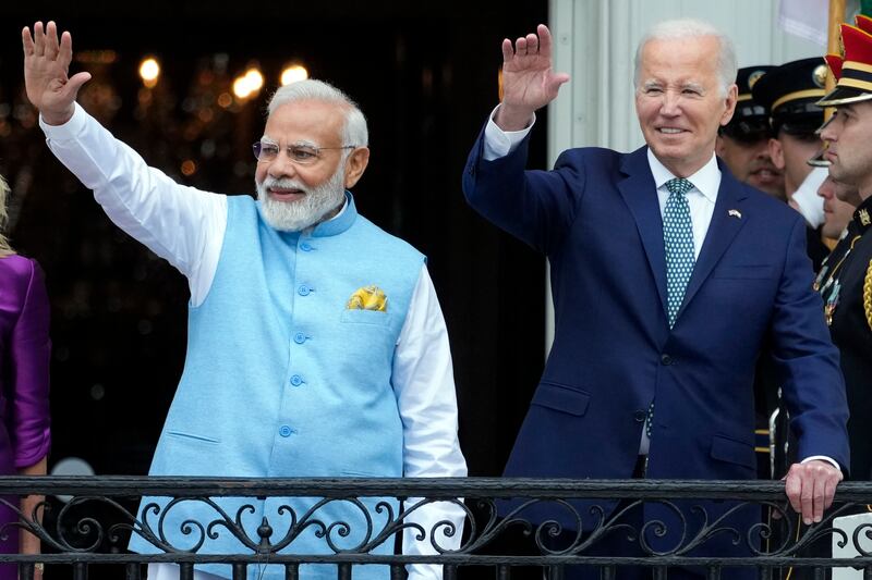 India’s Prime Minister Narendra Modi and President Joe Biden wave from the Blue Room Balcony of the White House in Washington.