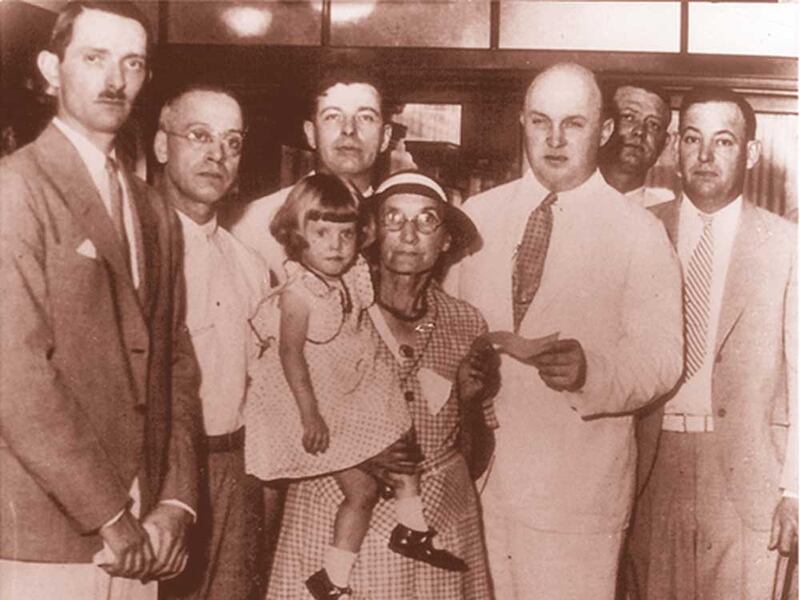 Lydia Lobsiger receives a check as the first FDIC beneficiary in 1934.