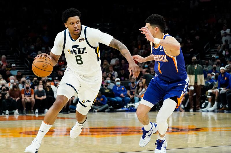 Utah Jazz forward Rudy Gay drives on Phoenix Suns guard Devin Booker during game, Monday, Jan. 24, 2022, in Phoenix.