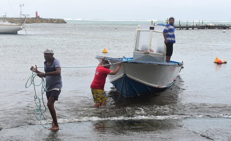 Men remove a boat from the water ahead of Hurricane Maria in the Galbas area of Sainte-Anne on the French Caribbean island of Guadeloupe, early Monday, Sept. 18, 2017. Hurricane Maria grew into a Category 3 storm on Monday as it barreled toward a potentia