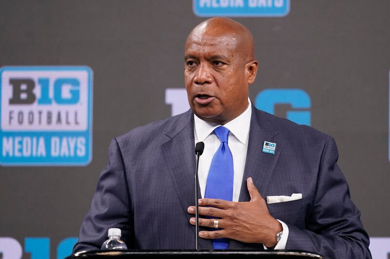 Big Ten Commissioner Kevin Warren, wearing a suit, talks to reporters