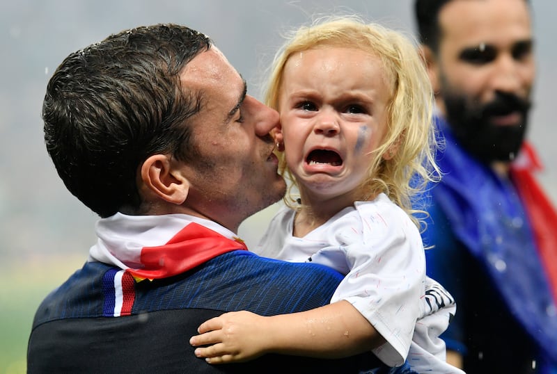 France’s Antoine Griezmann carries his crying daughter after his team won the final match between France and Croatia at the 2018 soccer World Cup, Sunday, July 15, 2018.
