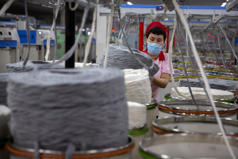 A worker gathers cotton yarn at a textile manufacturing plant in Aksu in western China’s Xinjiang Uyghur Autonomous Region.