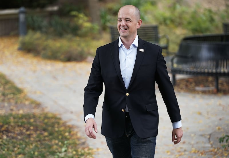 U.S. Senate candidate Evan McMullin walking outside wearing a black suit.