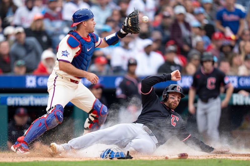 Cleveland Guardians' Daniel Schneemann, right, slides into home as Philadelphia Phillies catcher J.T. Realmuto, left, waits for the ball during game, Sunday, May 24, 2026, in Philadelphia.