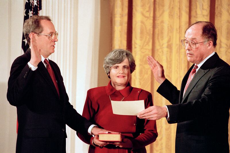 FILe - In this Feb. 18, 1988, file photo Anthony Kennedy, left, takes the constitutional oath as a Supreme Court Associate Justice from Chief Justice William Rehnquist at a White House ceremony in Washington. Holding the Bible is Kennedy's wife, Mary Kenn