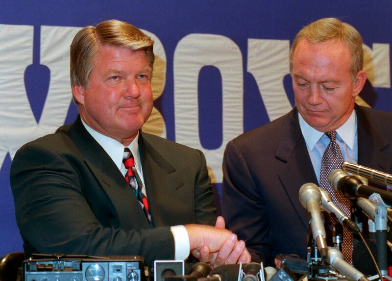 Jimmy Johnson, left, shakes hands with Dallas Cowboys owner Jerry Jones at a news conference in Irving, Texas, in 1994.
