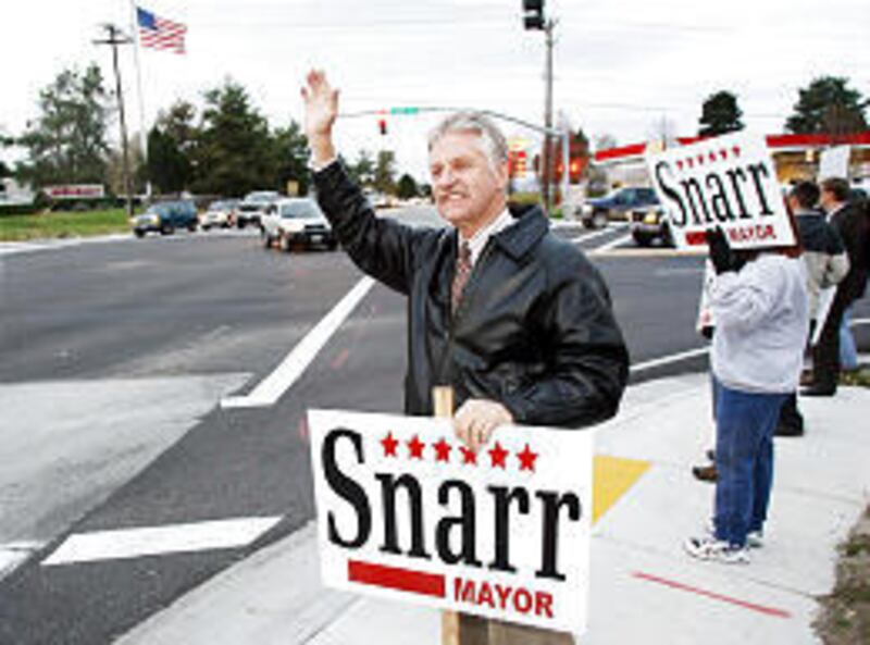 Murray's incumbent Mayor Dan Snarr waves to drivers as they pass at 5300 South and 700 West Tuesday. Dave Wilde challenged Snarr.