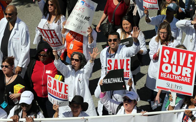 File - In this March 23, 2017, file photo, health care professionals join hundreds of people marching through downtown Los Angeles protesting President Donald Trump's plan to dismantle the Affordable Care Act. California and 17 other states that sued the