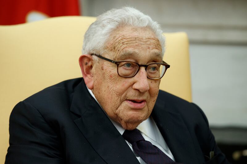 Henry Kissinger, wearing glasses, speaks during a meeting with President Donald Trump in the Oval Office in 2017,