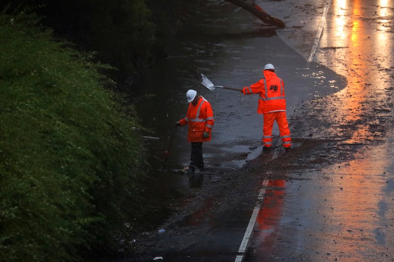 A Caltrans crew works to clear a flooded portion of northbound Highway 13 in Oakland, Calif.