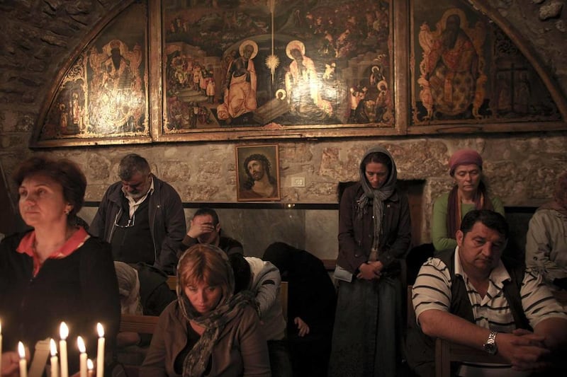 Christian pilgrims pray ahead of the Washing of the Feet ceremony inside the Chapel of St John and Baptistery, in the Church of the Holy Sepulchre, the site where many Christians believe Jesus was crucified and buried, in Jerusalem's Old City, Thursday, A