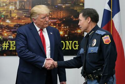 FILE - President Donald Trump shakes hands with El Paso Police Chief Greg Allen, Wednesday, Aug. 7, 2019, in El Paso, Texas. Trump paid visits to cities reeling from mass shootings that left multiple people dead and wounded.