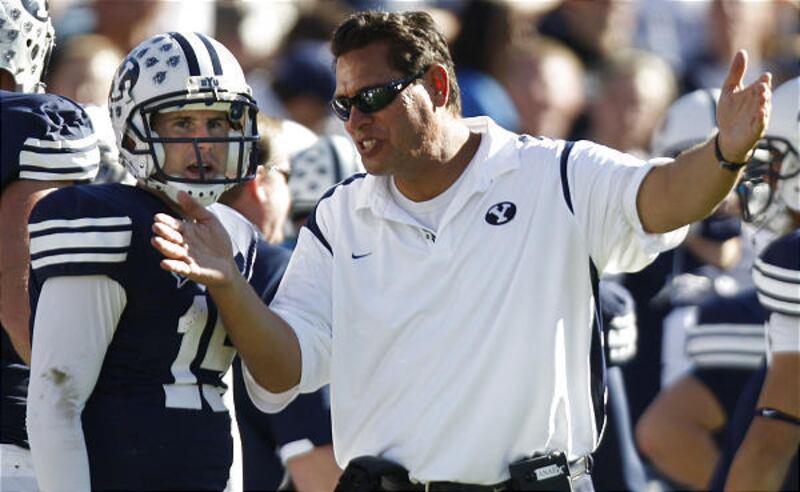 BYU offensive coordinator Robert Anae coaches up quarterback Max Hall on the sidelines.