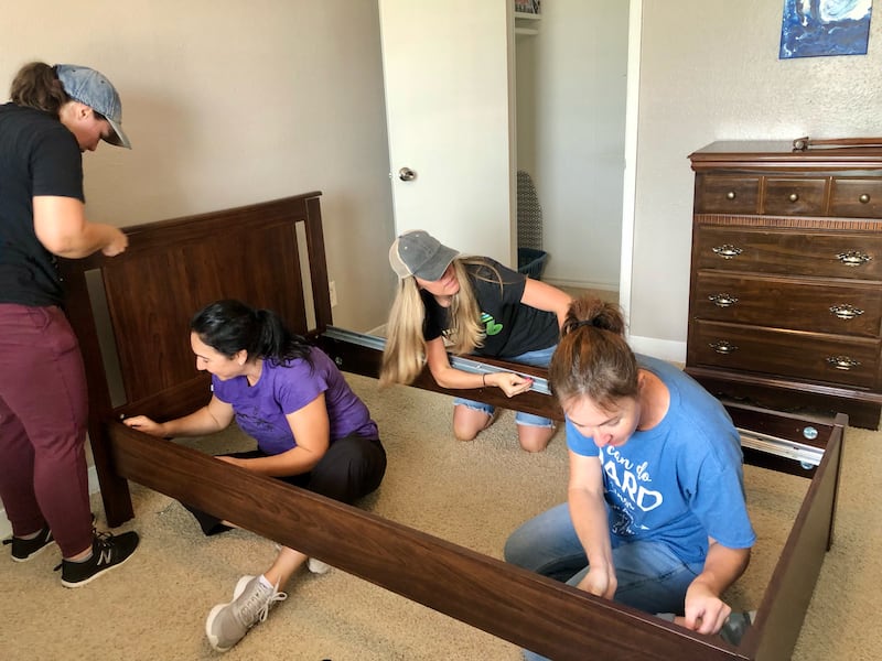 Volunteers assemble a bed as part of an on-going service project to furnish apartments for incoming refugee families in Houston.
