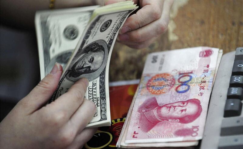 A Chinese clerk counts U.S. dollars in exchange for the Chinese renminbi at a bank in Hefei in central China's Anhui province Sunday June 20, 2010. China's central bank said Sunday it would maintain a stable exchange rate and didn't anticipate major chang