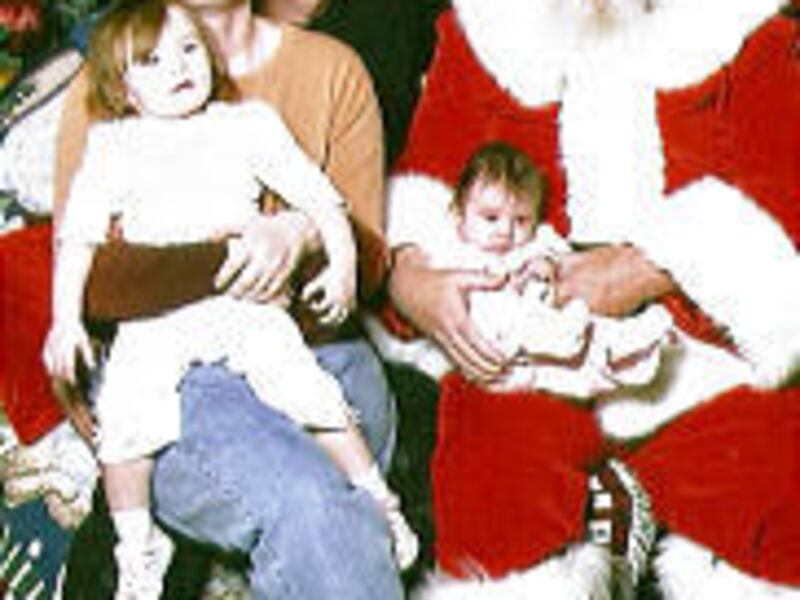 Rachael and Rick Norton with Trinity, 1, and Faith visit Santa Claus. Faith was born a month after Destiny was slain.