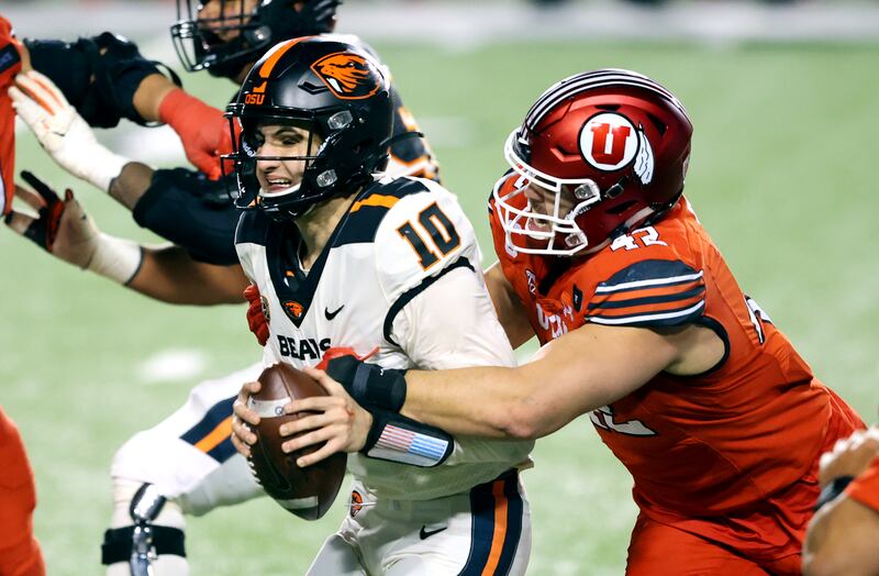 Utah Utes defensive end Mika Tafua (42) brings down Oregon State Beavers quarterback Chance Nolan (10).
