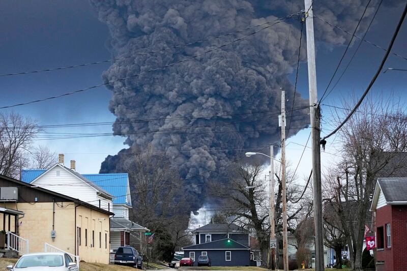 A black plume rises over East Palestine, Ohio, as a result of a controlled detonation of a portion of the derailed Norfolk Southern trains, Feb. 6, 2023. Ohio residents have cited nausea and headaches from the chemical leaks.