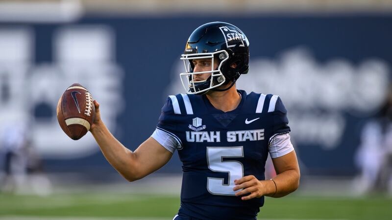 Utah State quarterback Cooper Legas (5) looks to hand the football back to the referee after a play during an NCAA football game on Oct. 7, 2023.