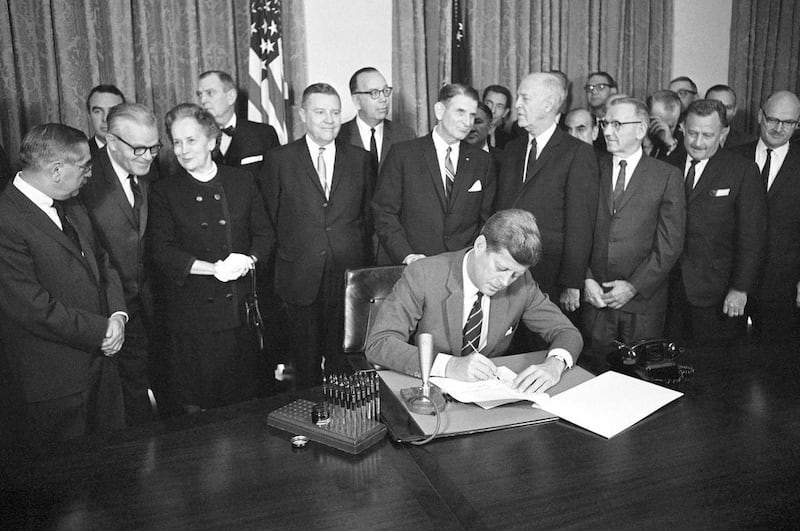 In this Oct. 31, 1963 file photo, President John F. Kennedy signs a bill authorizing $329 million for mental health programs at the White House in Washington. The Community Mental Health Act, the last legislation that Kennedy signed, aimed to build 1,500