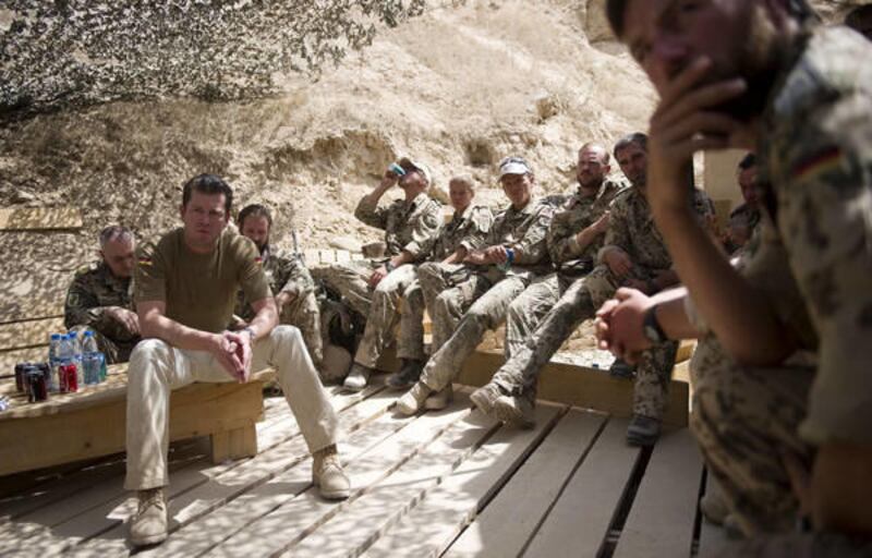 Former German Defense Minister Karl-Theodor zu Guttenberg, sitting left, visits German soldiers, on Sunday, Aug. 29, 2010, near Kunduz in Afghanistan.