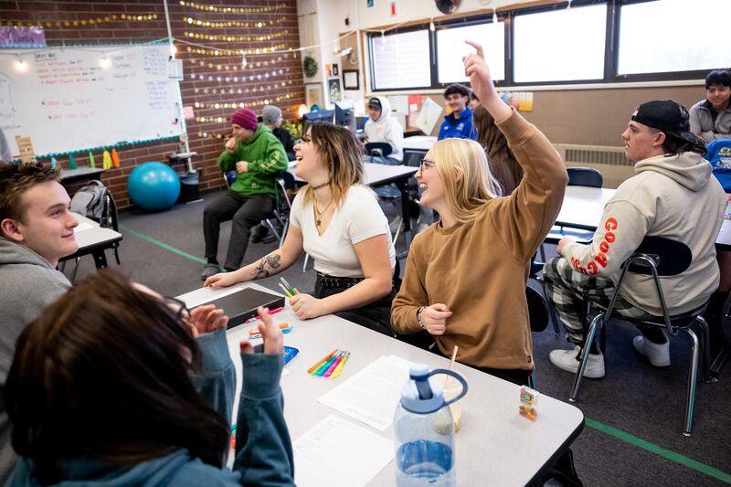 Tori Poulsen, 18, center, and Lily Williams, 17, right, laugh during a review game being played in their English class at Cyprus High School in Magna on Friday, Jan. 27, 2023.