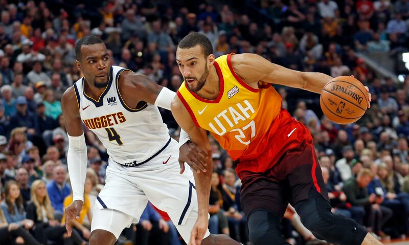 Utah Jazz center Rudy Gobert (27) drives around Denver Nuggets forward Paul Millsap (4) in the second half during an NBA basketball game Tuesday, April 9, 2019, in Salt Lake City.