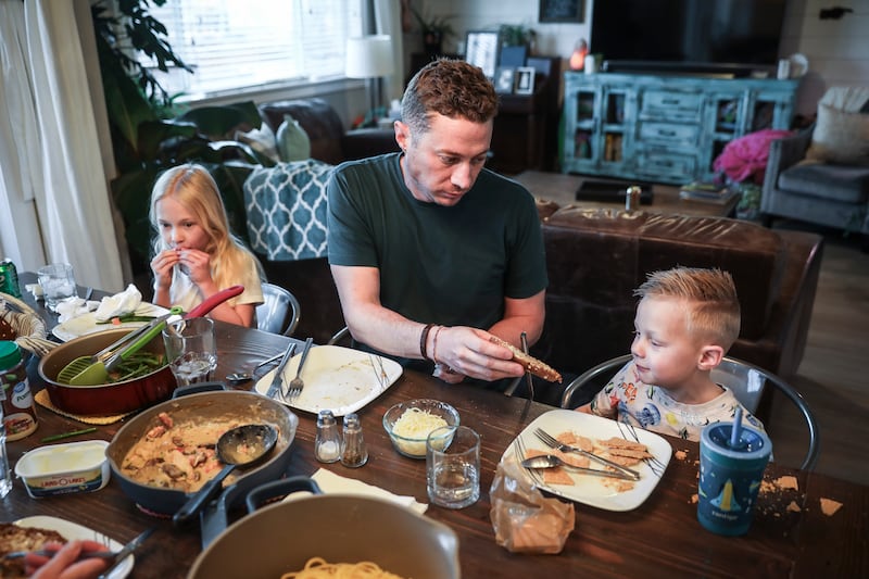 Tyson Wyatt of Castle Rock, Colorado, tries unsuccessfully to convince his son TJ, 5, to try some buttered bread at the dinner table as his daughter Charlotte, 8, eats in the background