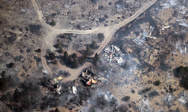 FILE - In this aerial photo, burned down structures are seen as a wildfire continues to burn east of Strawberry Reservoir, in Wasatch County, Utah, on Tuesday, July 3, 2018.