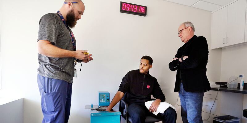 Scott Ellis, left, administers a cold presser pain tolerance test to Kendall Huey with Dr. Lynn Webster of PRA Health Sciences at right in Millcreek on Thursday, Oct. 19, 2017. PRA Health Sciences employees take the test to learn what subjects go through.