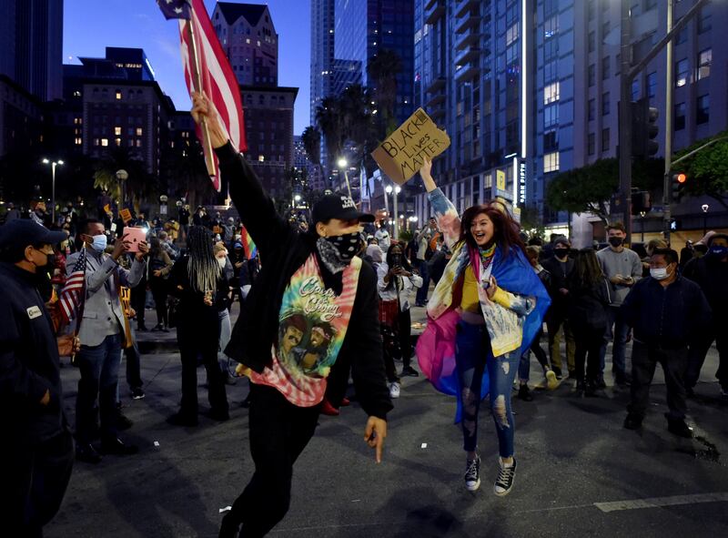 Da’Monte Trevino waves the American flag as people celebrate the victory of President-elect Joe Biden and Vice President-elect Kamala Harris, Saturday, Nov. 7, 2020 in Los Angeles.