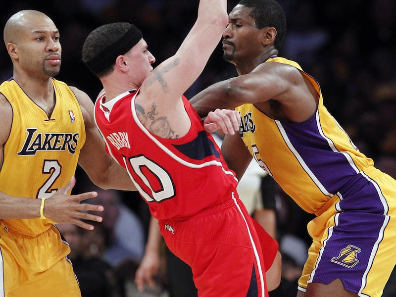 Los Angeles Lakers forward Ron Artest, right, give Atlanta Hawks guard Mike Bibby (10) a forearm block for a foul as lakers guard Derek Fisher (2) watches during the first half of an NBA basketball game, Tuesday, Feb. 22, 2011, in Los Angeles.