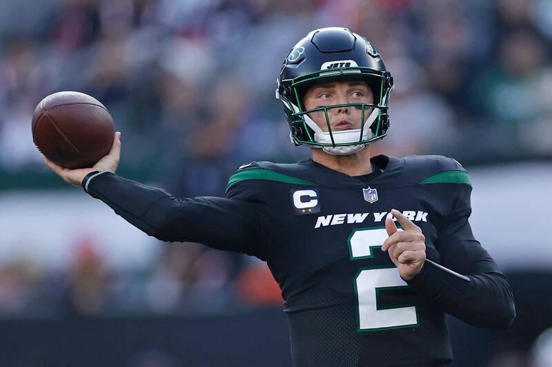 New York Jets quarterback Zach Wilson (wearing black) passes against the New England Patriots