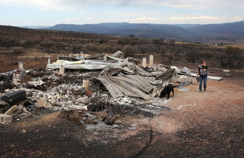 Linda Adams walks around what's left of her house in Fruitland on Wednesday, July 11, 2018. The house was destroyed in Dollar Ridge Fire.