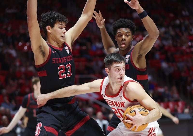 Utah Utes guard Lazar Stefanovic (wearing white) looks to pass on the defense by Stanford Cardinal forward Brandon Angel (23)