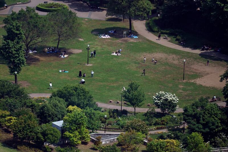 People enjoy the sun at a park in Tokyo Thursday, May 28, 2020. Japanese Prime Minister Shinzo Abe announced the lift of a coronavirus state of emergency from Tokyo and four other remaining areas on Monday, ending the restrictions nationwide as businesses begin to reopen. (AP Photo/Eugene Hoshiko)
