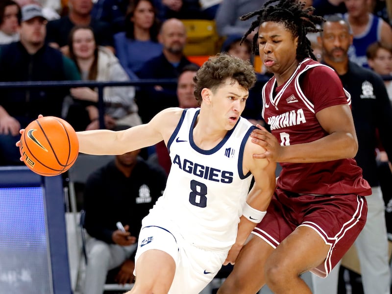 Utah State graduate guard Drake Allen (8) drives against Montana forward Money Williams during USU’s 95-83 win on Nov. 18 at the Spectrum in Logan.