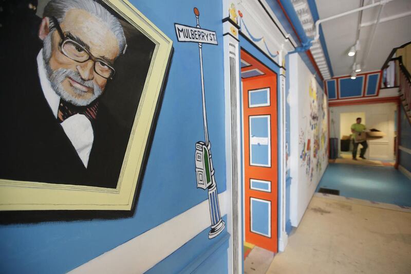 In this May 4, 2017, photo a mural that features Theodor Seuss Geisel, left, also know by his pen name Dr. Seuss, rests on a wall near an entrance at The Amazing World of Dr. Seuss Museum, in Springfield, Mass. The new museum devoted to Dr. Seuss opened o