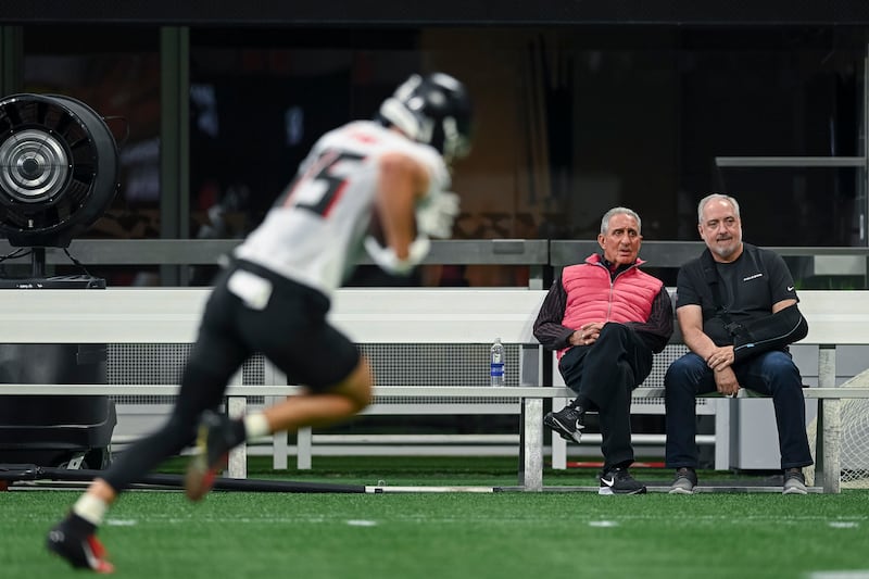 Brett Jewkes, right, sits with Atlanta Falcons owner Arthur Blanks during a Falcons practice.