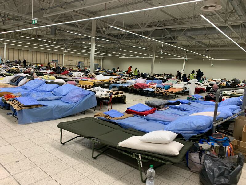 This picture shows a one of several rooms filled with cots in refugee center in Poland.