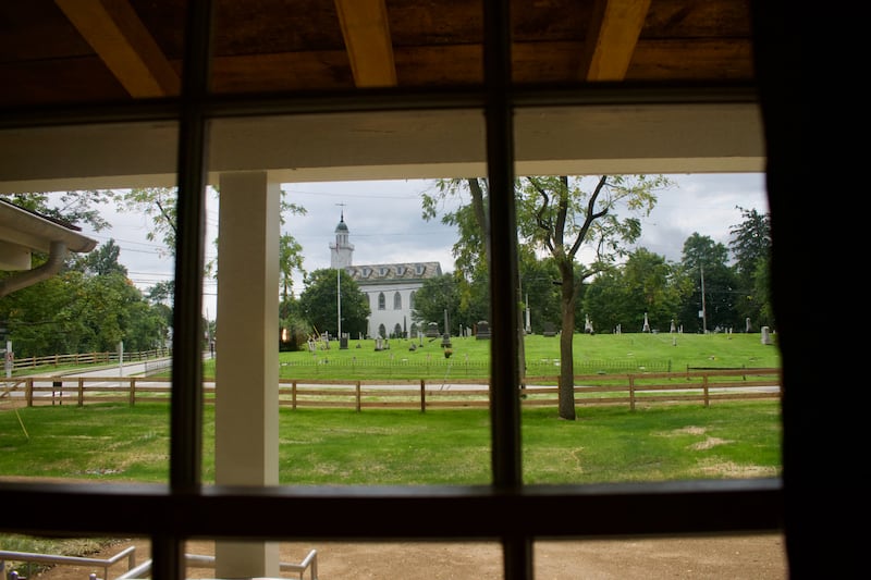 The Kirtland Ohio Temple is seen through a window of the Joseph and Emma Smith home in August 2023.