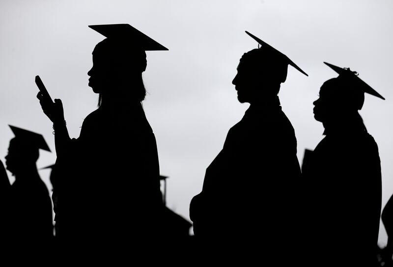 FILE- In this May 17, 2018, file photo, new graduates line up before the start of the Bergen Community College commencement at MetLife Stadium in East Rutherford, N.J. Obtaining a college degree has increasingly coincided with ever-higher student debt loa