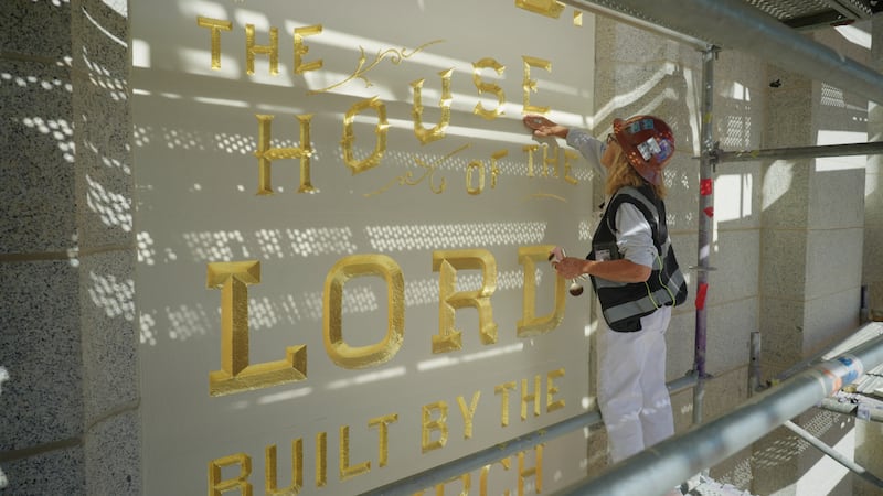 Anne Domenech, an artist with Evergreen, works to restore the "Holiness to the Lord" panel on the Salt Lake Temple of The Church of Jesus Christ of Latter-day Saints on Tuesday, Aug. 19, 2025.