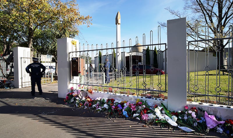 A constable is stationed outside the Al Noor Mosque in Christchurch, New Zealand on Tuesday, May 21, 2019. Flowers have been placed along the wall.