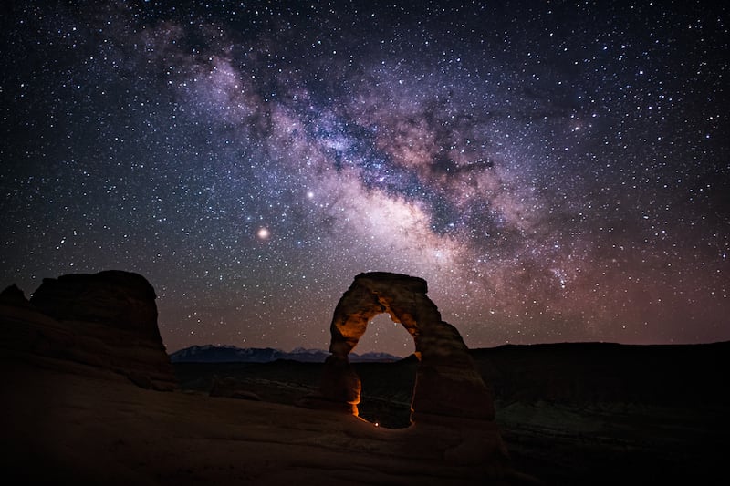 Delicate Arch looms in front of the night sky in Arches National Park.