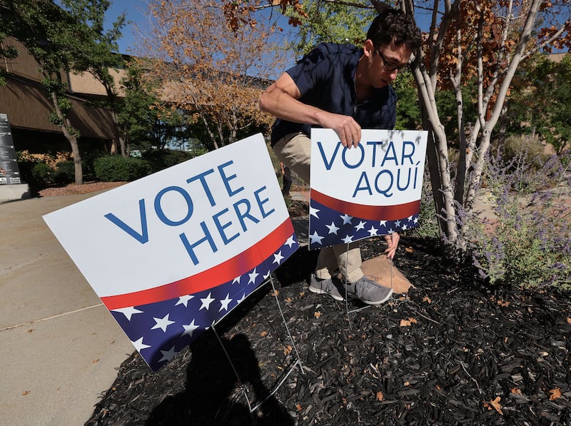 Election coordinator Dimitri Sakellariou displays voting signs at the Salt Lake County Government Center.