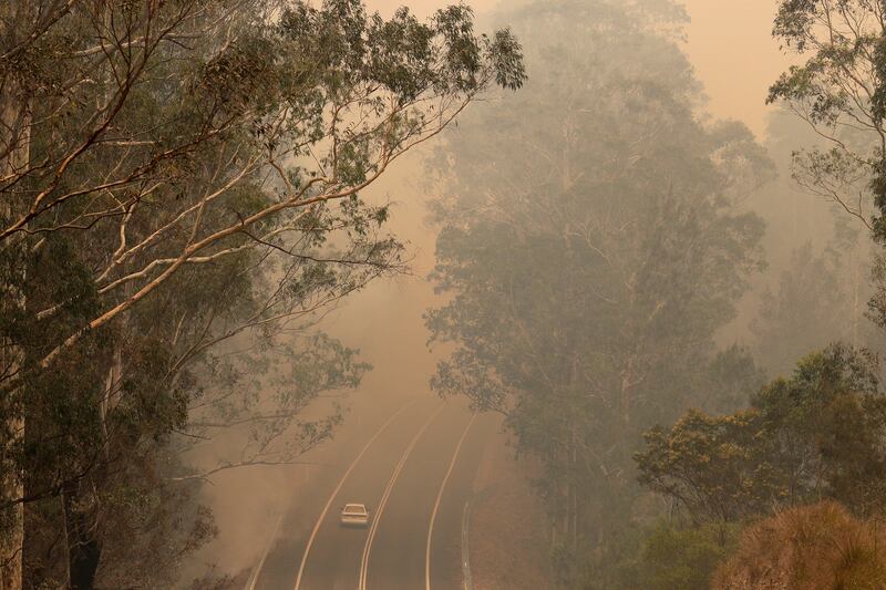 Smoke from wildfires shrouds a road near Moruya, Australia, Saturday, Jan. 4, 2020.