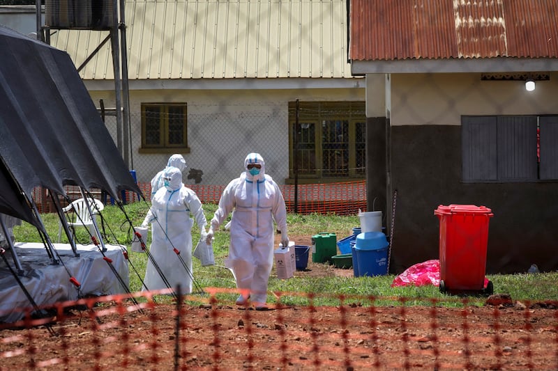 Doctors walk inside the Ebola isolation section of Mubende Regional Referral Hospital, in Mubende, Uganda.