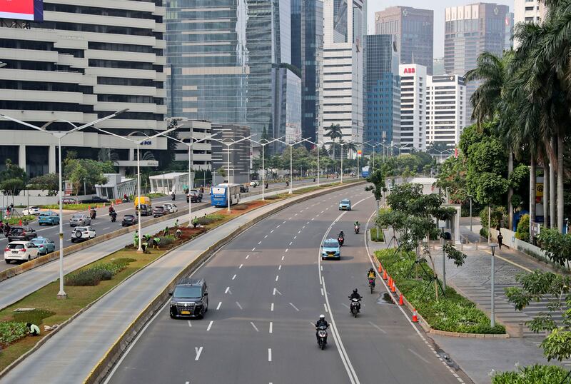 Cars and motorcycles are seen on Sudirman street that is usually busy with traffic, at the main business district in Jakarta, Indonesia, Monday, Sept. 14, 2020. Indonesia’s capital on Monday begins to reimpose large-scale social restrictions to control a rapid expansion in the virus cases.